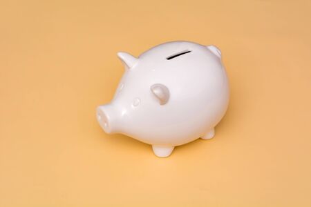 White pig piggy bank on a beige backgroundの写真素材