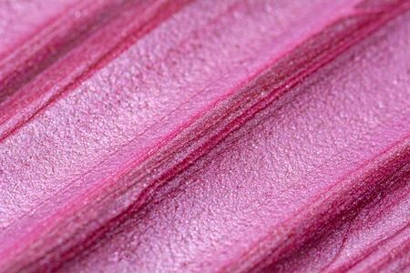 Texture of lip gloss. Smudged makeup product sample. Sparkling backgroundの写真素材