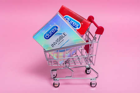 Kyiv, Ukraine - 15 July 2020: Durex condoms in a shopping trolley on the pink background. Durex...