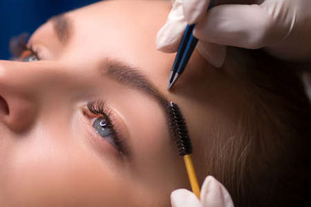 Beautician plucking eyebrows. Eyebrow care in a beauty salonの写真素材