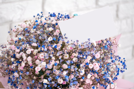 A bouquet of delicate small flowers in a box with a note.の写真素材