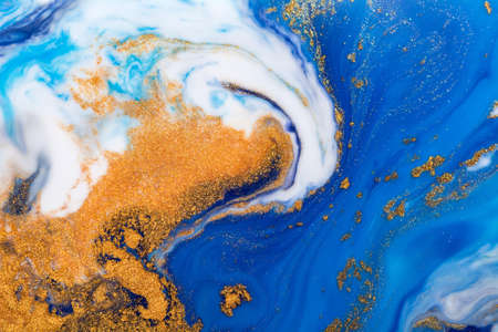 Luxury fluid art painting background. Spilled blue, white and gold acrylic paint. liquid marble. Alcohol ink splash.の写真素材