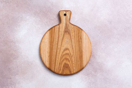 Wooden cutting board on a light background. Kitchenware top view. Empty space for your ready meals.の写真素材
