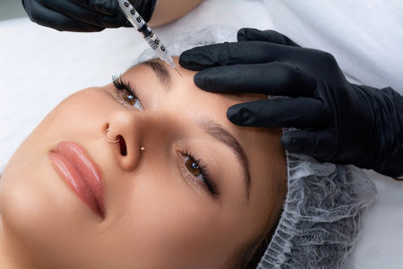 A beautician gives a woman a Botox injection. A procedure for beauty and rejuvenation.の写真素材