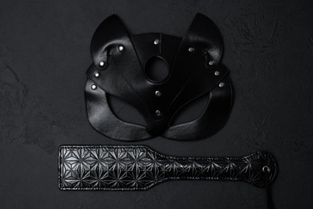Black leather mask and adult toy on a white background, top viewの写真素材