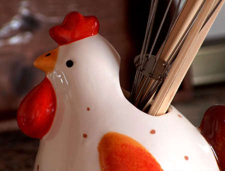 Decorative porcelain chicken with kitchen utensils.の写真素材