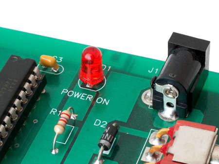 Dusty printed circuit board with some components soldered in. From the bottom left: integrated...