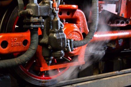 forgiveness of steam from the steam line at the old locomotive wheelの写真素材