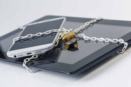 symbolic ensuring smartphone and tablet by chain and pulleyの写真素材