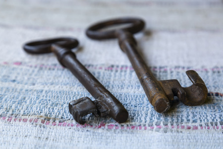 two old keys on a colored rural woven carpetの写真素材