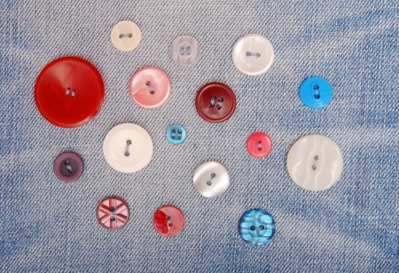 Variegated buttons are sewn on denim 