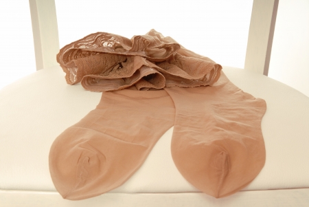 Pair of nylon stockings  hang on back of chair 