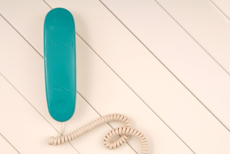 home telephone is on white background, green phone device is on table, empty space and panel texturing backgroundsの写真素材