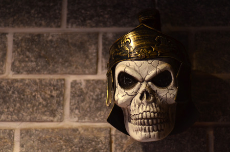 Skull of a Roman soldier with centurion helmet pinned to the wallの写真素材