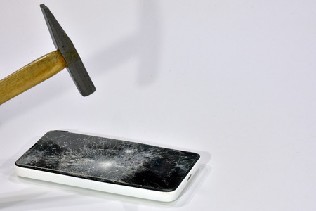 Cell phone with the screen broken by a hammerの写真素材