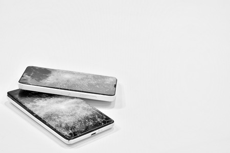 Cell phone with the screen broken by a hammerの写真素材