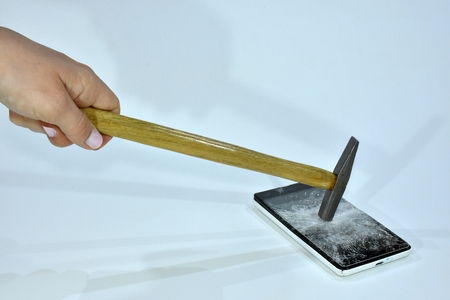 Cell phone with the screen broken by a hammerの写真素材