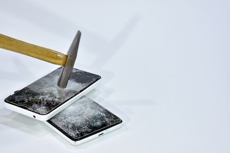 Cell phone with the screen broken by a hammerの写真素材