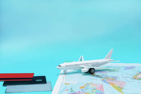Travel theme. Airplane on world map and credit cards on blue background with copy space.