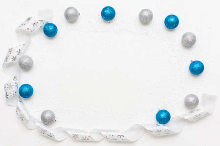 Holiday round Frame with blue and silver Christmas balls and white ribbon. Flat lay with copy space