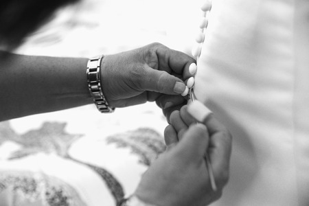 Hands detail with a mother dressing her daughter for the wedding