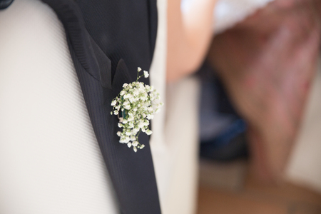 Detai of a groom's jacket on a chair, with flowerの写真素材