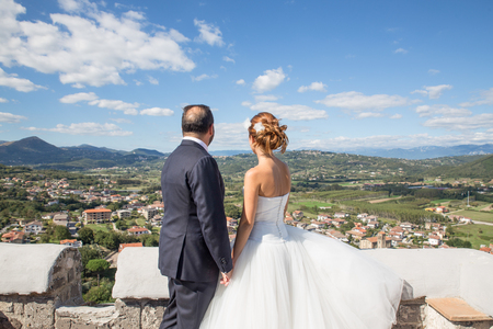 Bride and groom looking at the landscapeの写真素材
