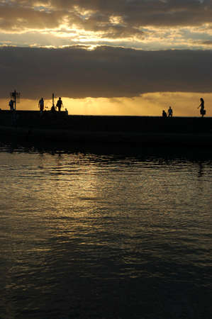 Silouhette of people walking on a pier at Runion Islandの写真素材