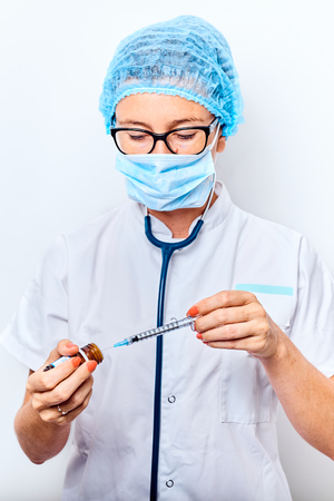 Woman doctor filling medicine from ampule into syringe.の写真素材
