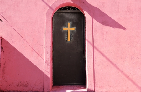 Golden cross on a metal door of churchの写真素材