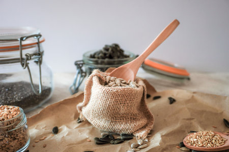 bag with sunflower seeds and wooden spoon brown background with white copy spaceの写真素材