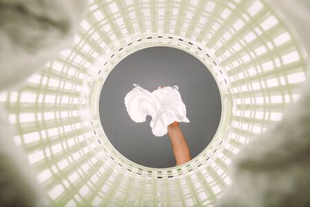 White cloth thrown into the basket to wait for washing. View from the inside of the basket.の写真素材