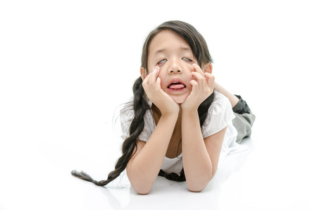 Little cute asian girl resting chin by hand on whiteの写真素材