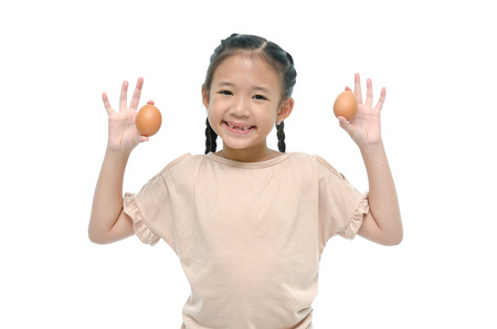 Little asian girl smiiing and holding eggの写真素材