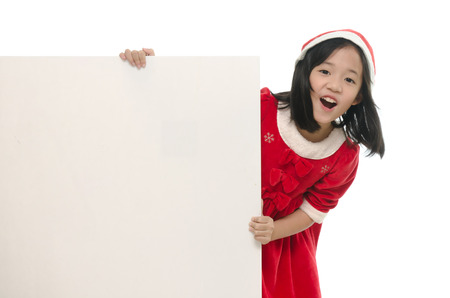 Beautiful asian girl in santa hat and red comforter behind white board onwhite back ground isolatedの写真素材