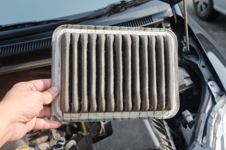 technician holding dirty air filter for carの写真素材