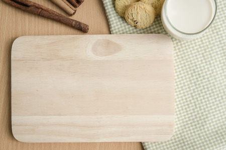 Wooden tray,glass of milk,cookies and cinnamon on tableの写真素材