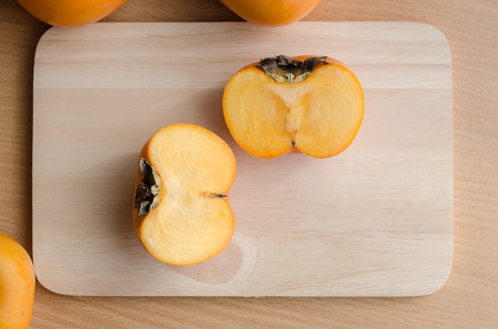 Close up of persimmon on wooden table with copy spaceの写真素材