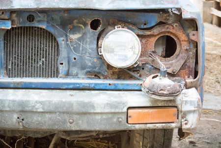 Headlight of  an old and damaged blue vehicleの写真素材