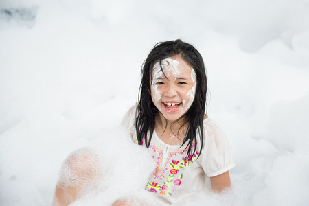 Little asian girl smiling in foam partyの写真素材