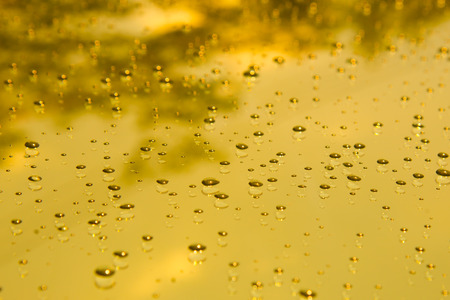 Gold water drops on mirror backgroundの写真素材