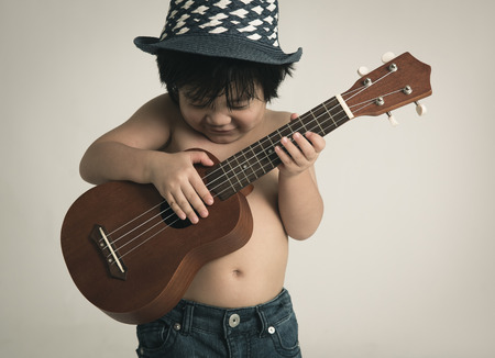 Little asian boy playing ukuleleの写真素材