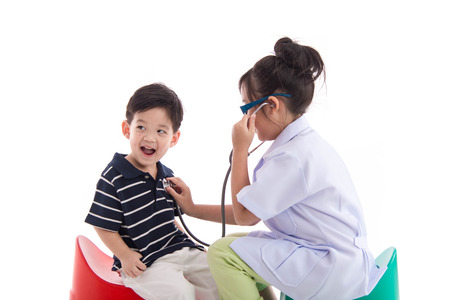 Asian children playing as doctor and patient on white background isolatedの写真素材