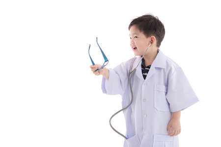 Cute asian child in a doctors uniform on white background isolated with copy spaceの写真素材
