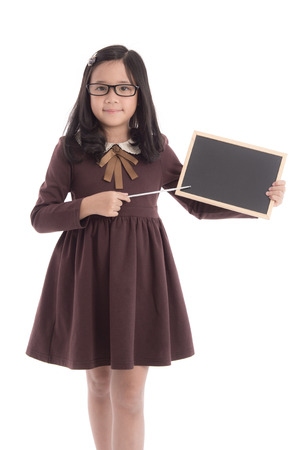Little asian girl in student uniform holding blackboard on white background isolatedの写真素材