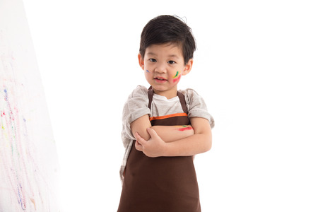 Cute little asian boy painting isolated on white backgroundの写真素材