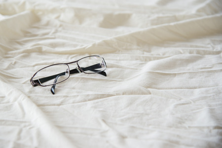 Modern Glasses on white bed in the morning sunday for backgroundの写真素材