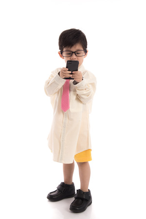 Little asian child pretending to be  businessman using smart phone on white background isolatedの写真素材