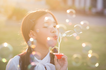 Cute asian girl is blowing a soap bubbles,vintage filterの写真素材