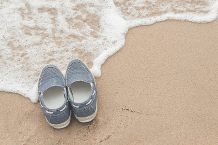 canvas shoes on sand beach with copy space on right,vintage filterの写真素材